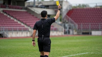 Arbitro con cartellino giallo